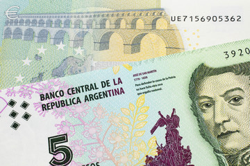 A five peso bill from Argentina, close up in macro with a red, five Euro European bank note