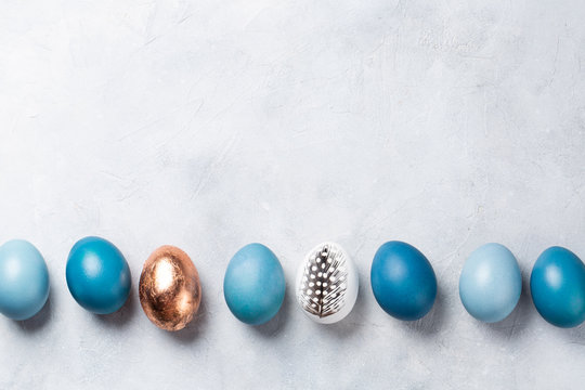 Festive blue Easter eggs on a light gray background. Top view. Space for text.