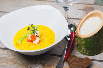 Traditional rice with seafood, risotto with rice and shrimp in a deep white plate on a table in a restaurant.