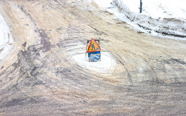 Road signs: repairs and detours. Snow removal in the winter city. An intersection with road signs...