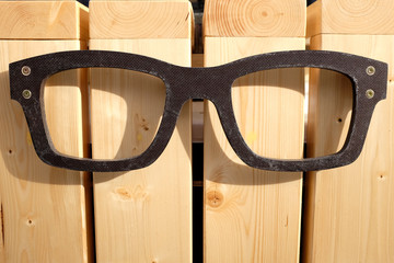black graphic glasses symbol icon on wooden background