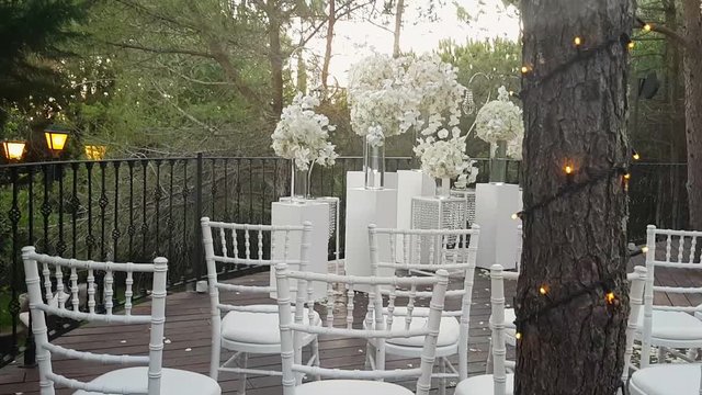 Wedding decorations flowers and white chairs, in a forest environment after the ceremony.