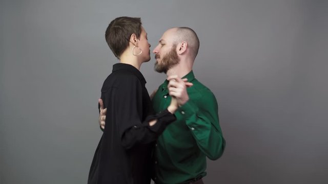 Romantic couple dancing on gray background. Man and woman are dancing slow blues dance. Sensual couple dancing.