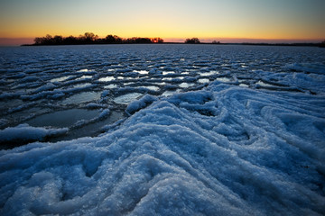 Sunrise and frozen river. Beautiful winter landscape with lake in morning time. Daybreak