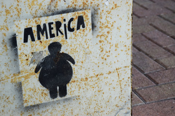 Graffiti on a tin wall commenting on obesity in America
