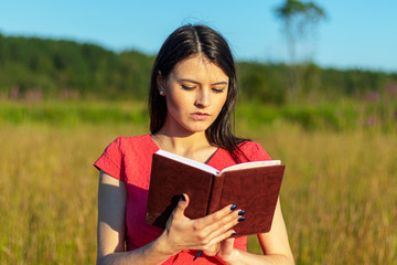 Fototapeta premium Caucasian girl with a notebook on nature