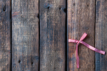 Small red bow on a wooden background. Love