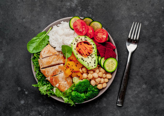 Bowl Buddha. rice, chicken breast, broccoli, pumpkin, avocado, chickpeas, carrots, cucumber, beets, a stone background