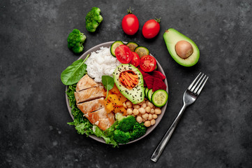 Bowl Buddha. rice, chicken breast, broccoli, pumpkin, avocado, chickpeas, carrots, cucumber, beets, a stone background
