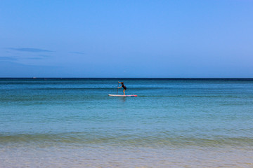 Standing up paddleboarding on beach in cornwall