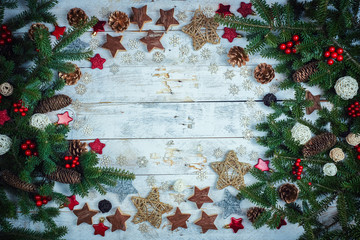 Christmas or New Year decoration background: fir-tree branches on a wooden background with copy space.