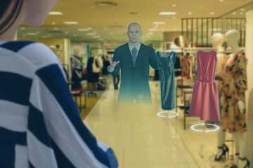 iot smart retail futuristic technology concept, happy girl try to use smart display with virtual or augmented reality  in the shop or retail to choose select ,buy cloths and give a rating of products