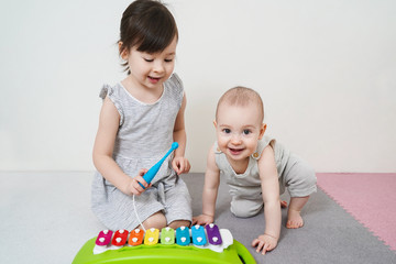 Two sisters play a xylophone. Early development of preschool children.