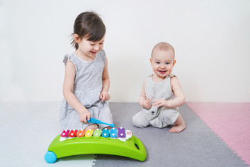 The older sister teaches the younger to play with toys. Early development of preschool children.