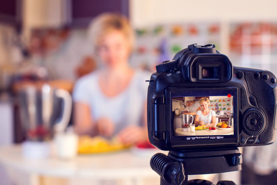 Woman food blogger cooking in front of camera and recording video. People, hobby and media concept