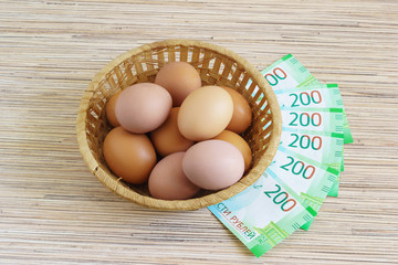 Real farm chicken eggs in a basket and Russian rubles. The purchase of food