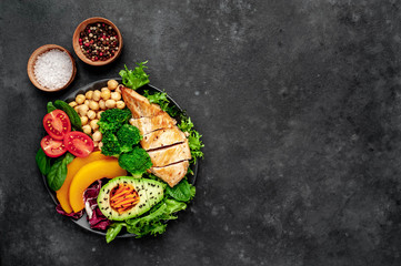 Bowl Buddha. chicken, broccoli, chickpeas, pumpkin, avocado, carrot, tomato on   a stone background  with copy space for your text
