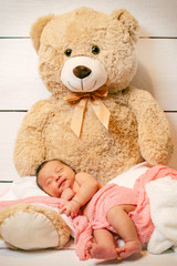 newborn sleeping on a teddy bear in studio