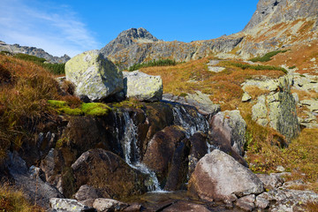 Small waterfall in autumn High Tatras mountain with stones and peaks at Skok waterfall and lake in Slovakia © andras_csontos