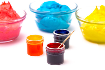 Opened Pots of Red Yellow and Blue Gel Food Coloring for Baking on a White Background
