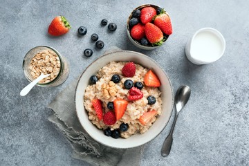 Bowl of healthy breakfast oatmeal porridge bowl served with summer berries. Table top view. Clean...