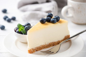 Plain New York Cheesecake Slice With Juicy Blueberries. Sweet Dessert On White Plate Closeup
