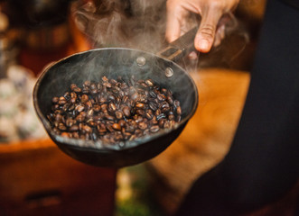 Coffee beans roasting in a cast iron pan