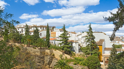 View of the city on the edge of a stone gorge - a channel of the Guadelevin River. Ronda, Spain, Andalusia.