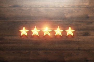 5 golden stars on a wooden background, assignment of a new rating, service rating, a new level, business concept. Mixed medium.