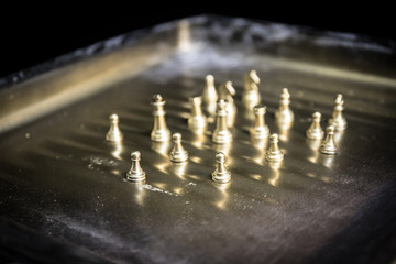 Chess figures on a dark background with smoke and fog. Selective focus