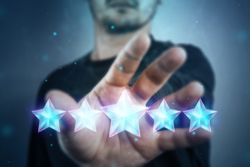 Close-up of a hand and 5 stars, assignment of a new rating, evaluation of services, a new level,...