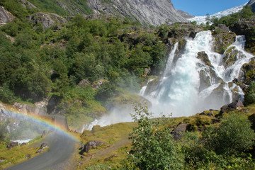 mountainous landscape with a large waterfall and rainbow