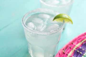 Mexican lime margarita cocktail on turquoise background