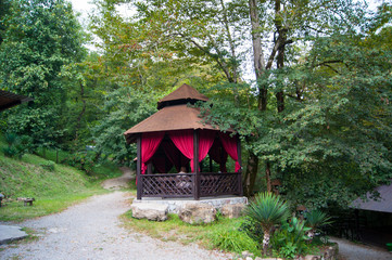Fototapeta na wymiar Open wooden brown gazebos in the mountains above the mountain river for outdoor food.