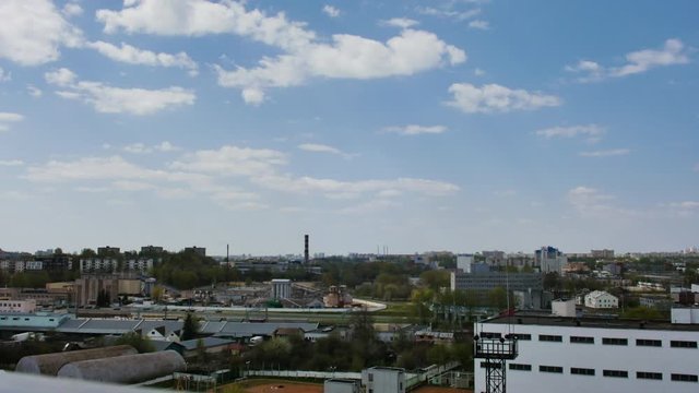 time lapse video with clouds floating in the blue sky on a sunny summer day over the cityscape in 4K.