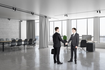 Businesspeople shaking hand in meeting room