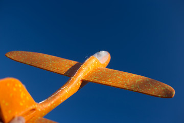 styrofoam yellow plane in the blue sky
