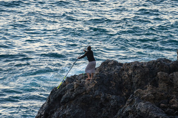 Fisher woman on the rocks