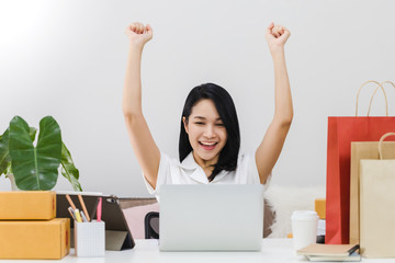 Asian beautiful woman working with laptop to online business shop at home.Owner businesswoman start up with Accept orders,Check the number of products, Prepare to deliver products to customers.