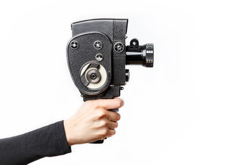 Female hand holding old style 8 mm movie camera on a white background