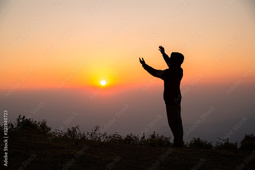 Wall mural Silhouette of man praying in the sunrise - Wall murals