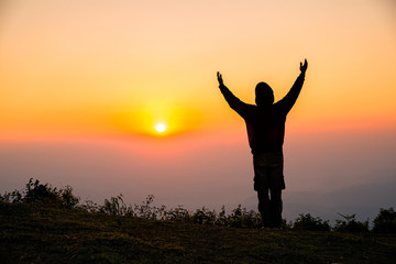 Fototapeta na wymiar Silhouette of man praying in the sunrise