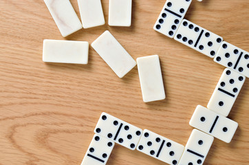 Playing dominoes on a wooden table. Dominoes game concept.