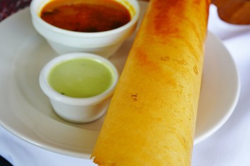 A plate with masala dosa bread stuffed with potatoes at an Indian restaurant