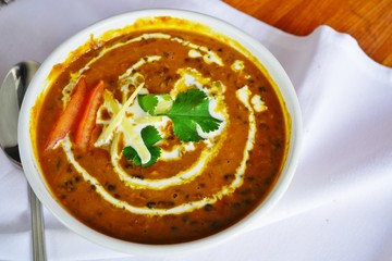 A dish of brown dal makhani lentil stew at an Indian restaurant