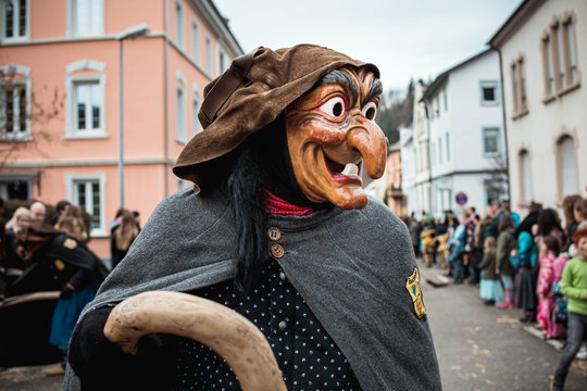 Schlosshexe aus Buchholz - Lustige Hexe mit gro&szlig;en Augen und langer Nase in dunklem Gewand und mit krumen Besen. Bei Fastnachtumzug in Waldkirch S&uuml;d Deutschland.