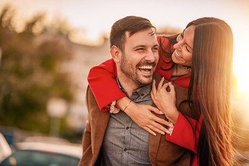 Happy young man piggybacking his girlfriend