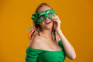 Beautiful woman dressed for carnival night. Smiling woman ready to enjoy the carnival with a colorful mask.