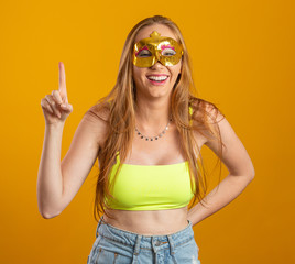 Beautiful woman dressed for carnival night. Smiling woman ready to enjoy the carnival with a colorful mask.