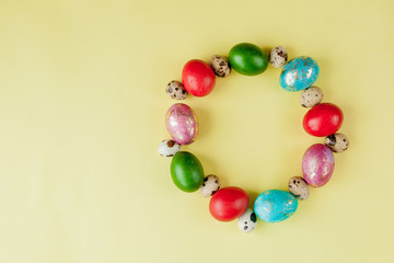 Top view painted eggs Easter Frame in circle shape on a yellow background. Copy space